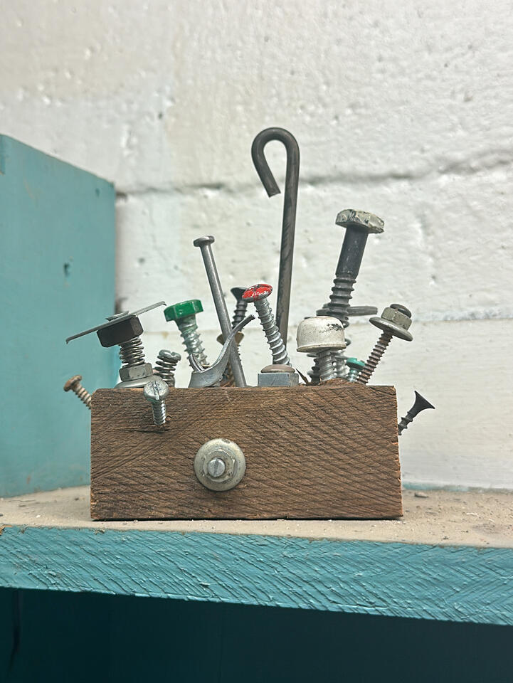 Close-up detail showing rough cuts of wood and vintage hardware sprouting out to make an abstract shelf decor